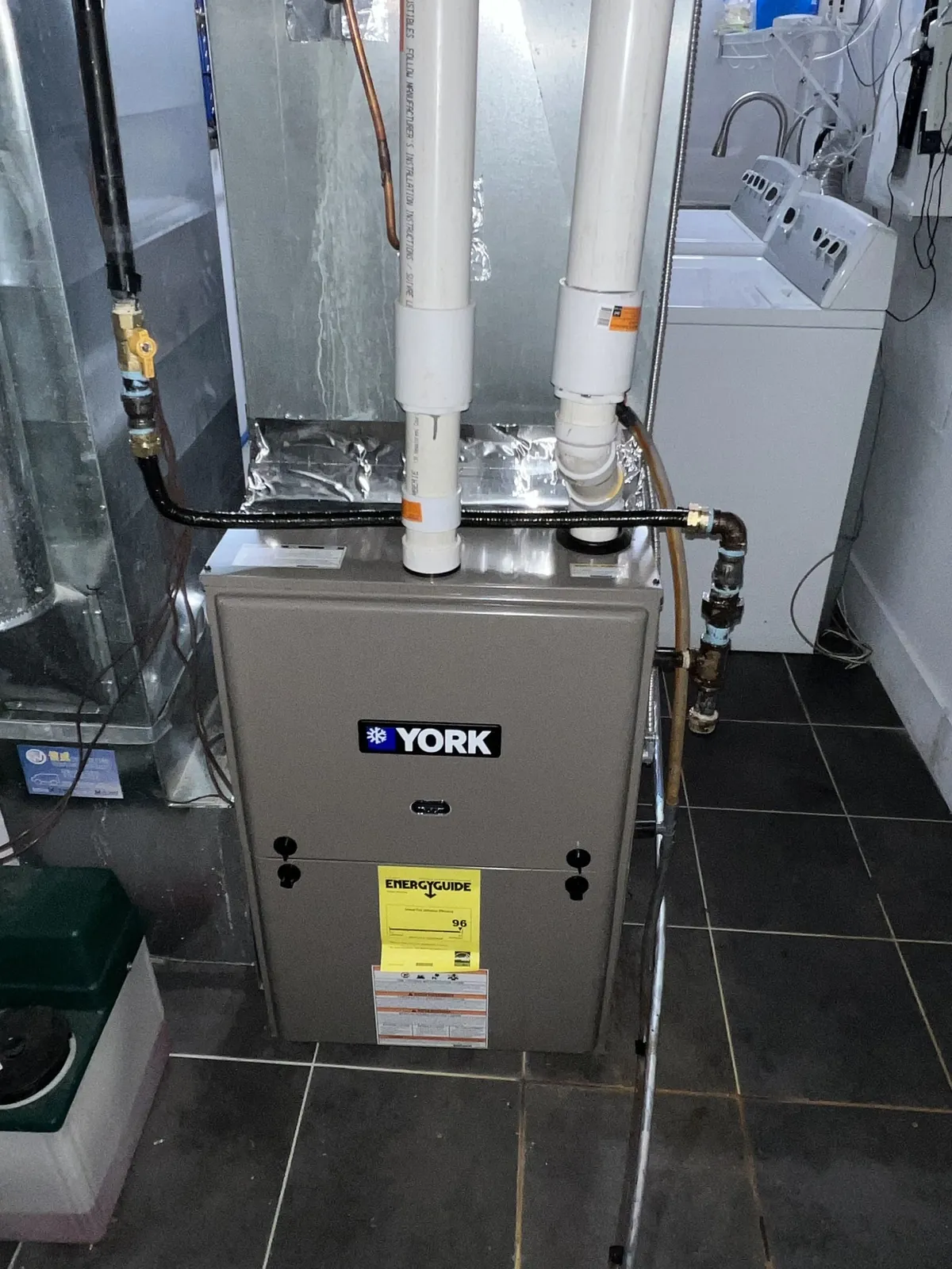 New York furnace installed on a tiled floor beside a laundry area in a Mississauga home