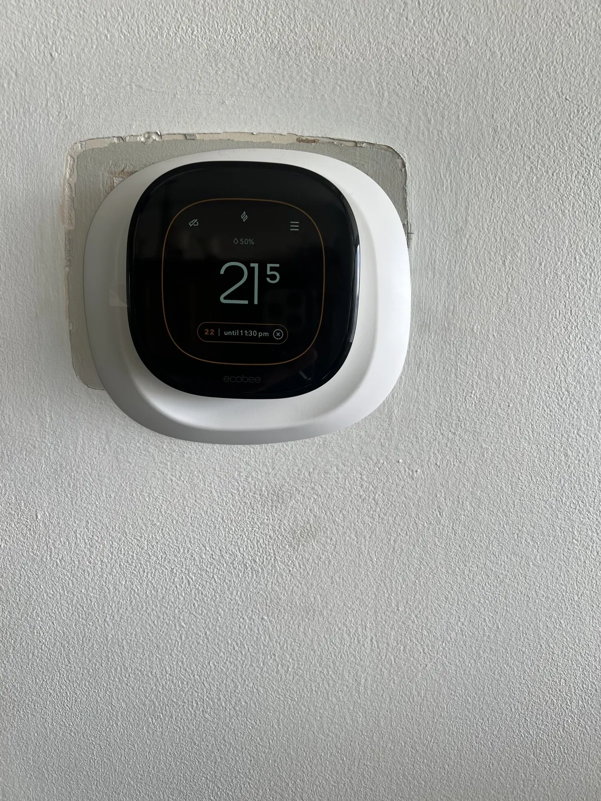 Wall thermostat showing a room temperature of 21 degrees