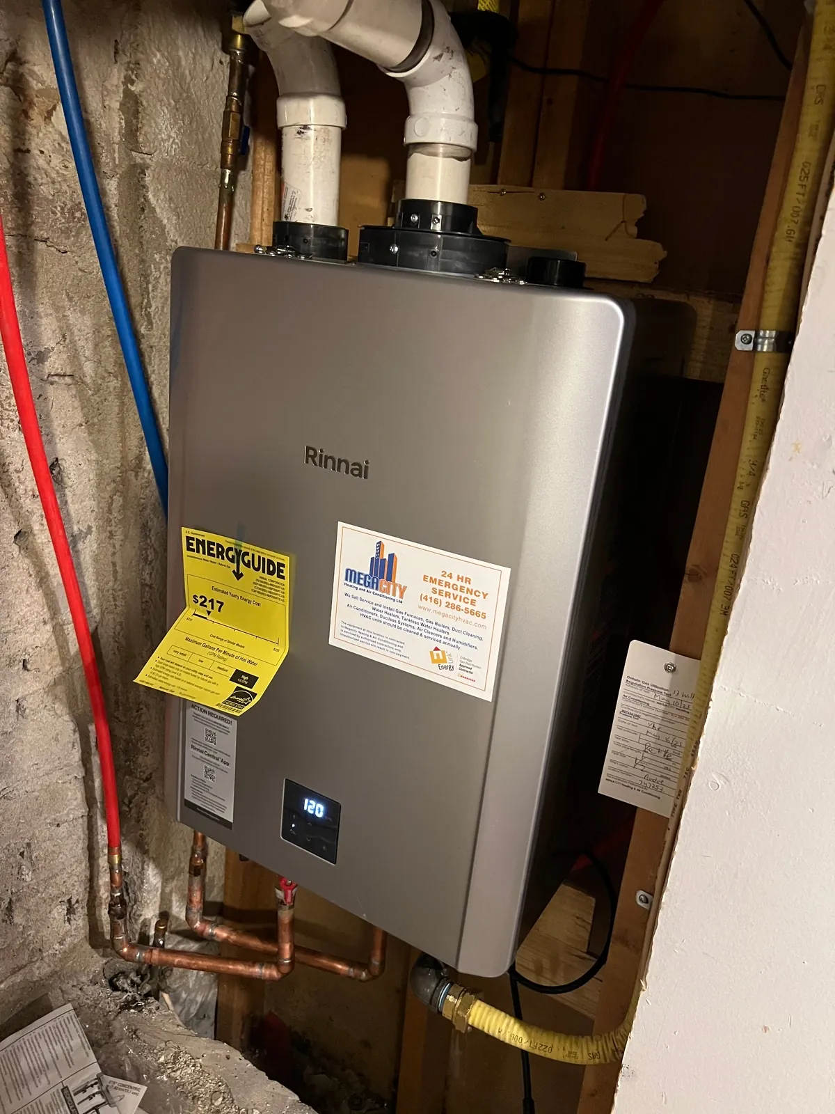 Wall-mounted Rinnai tankless water heater with the Energuide label still on the cabinet