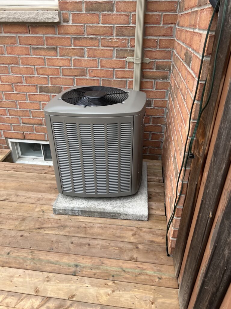 Outdoor air conditioning unit after repair on wooden deck in Mississauga home
