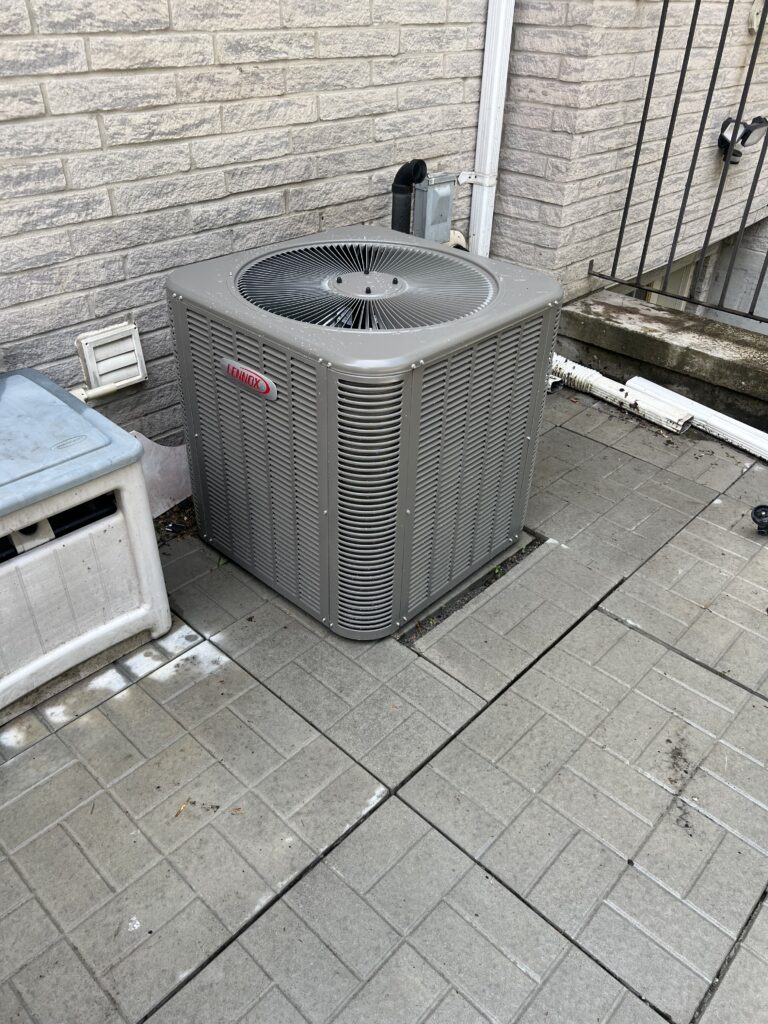 Lennox central AC condenser on leveled patio pavers with electrical disconnect — Mississauga home