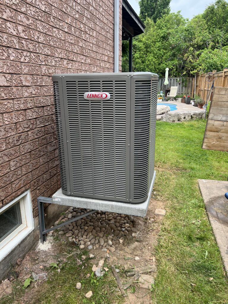 Lennox central air conditioner installed on raised wall bracket and concrete shelf — Mississauga backyard