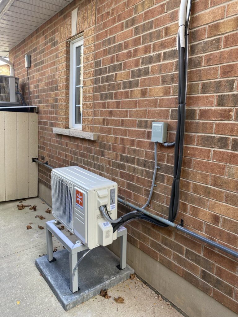 Woodland heat pump mounted on stand outside brick home in Mississauga.